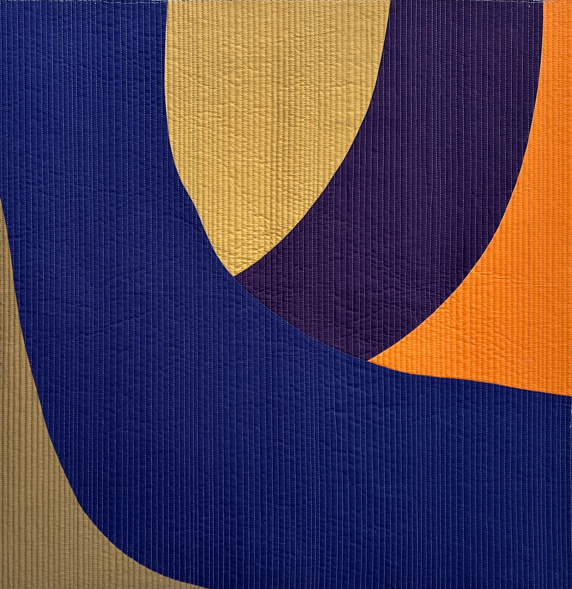 Abstract art quilt with blue, orange, and beige curved shapes
