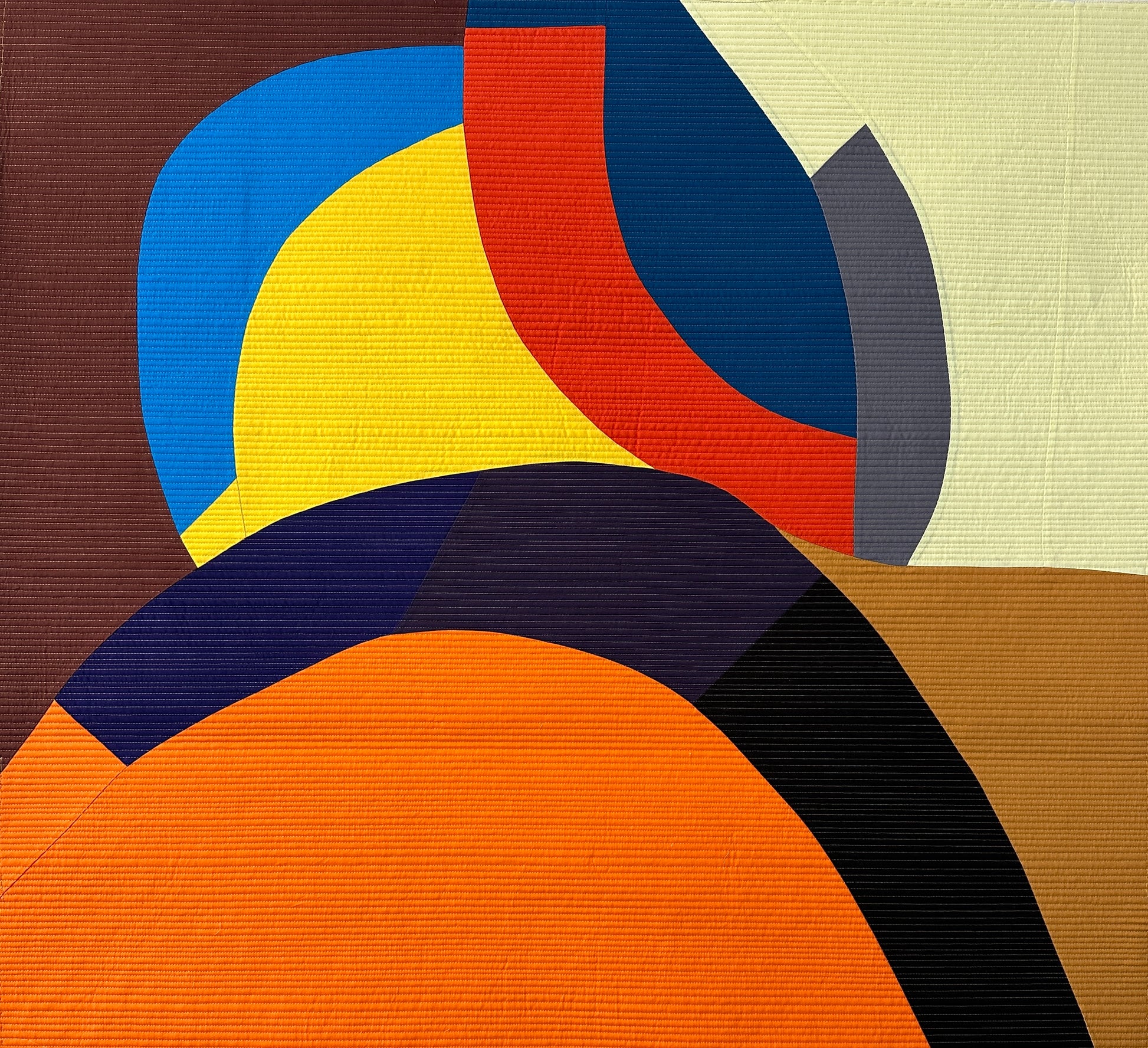 Abstract art quilt with curved shapes in blue, yellow, red, black, and orange