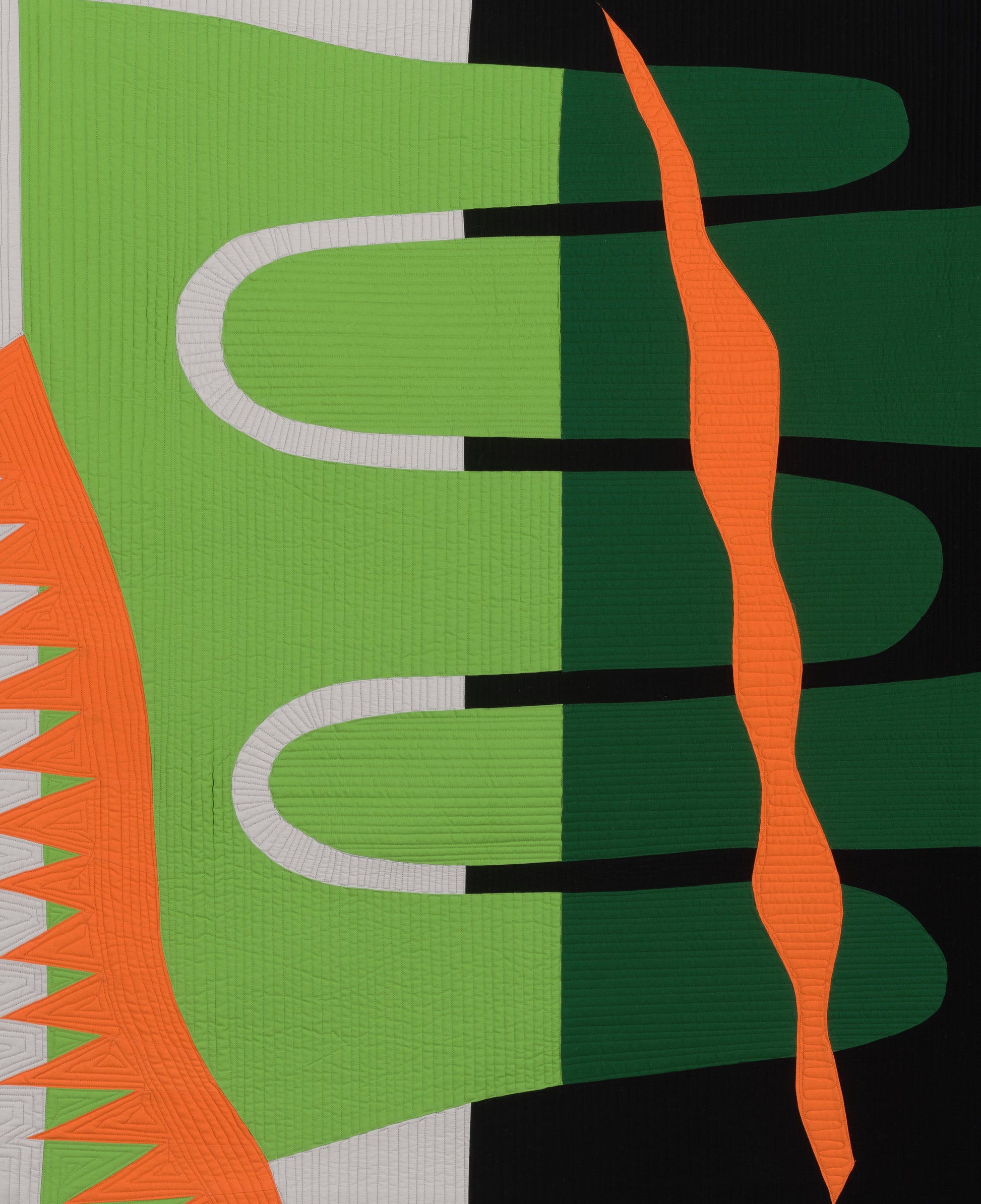 Abstract art quilt with geometric shapes in green, orange, black, and gray.